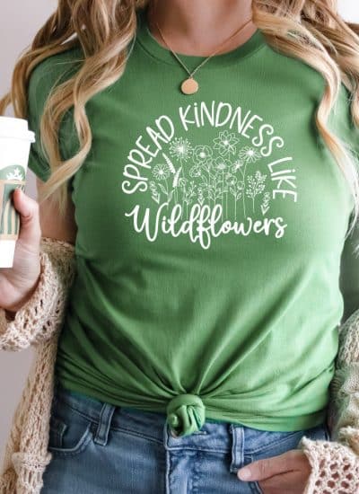 Woman with green shirt that reads Spread kindness like Widlflowers