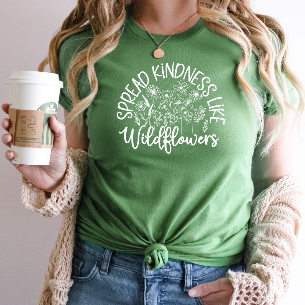 Woman with green shirt that reads Spread kindness like Widlflowers