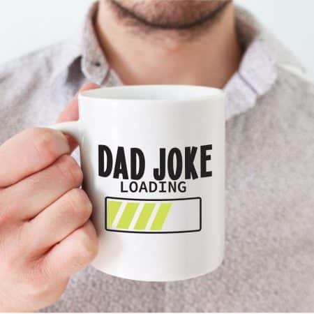 Man holding coffee mug wtih words that read "dad joke loading" with a loading bar