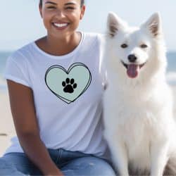 Woman in white shirt sitting with her dog and her shirt has a heart and paw print SVG design in square format