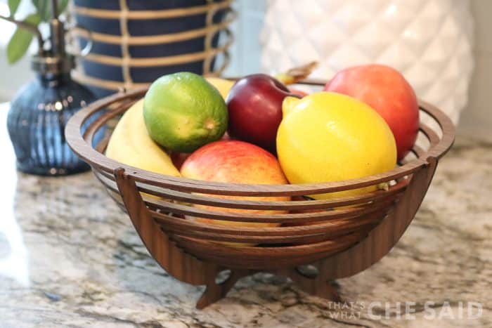 Walnut bowl made from xtool P2 laser cutter sitting on kitchen counter filled with fruit close up