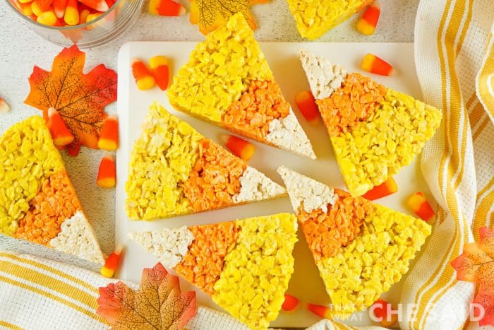 Yellow, Orange and White Rice Krispie Treats shaped like Candy Corn on a platter with fall decor