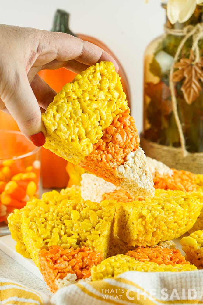 hand holiding a triangle candy corn rice krispie treat