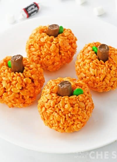 Rice Krispie treats on white plate with tooties rolls in background