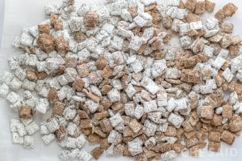 Fall Puppy Chow spread on parchemnt lined baking sheet