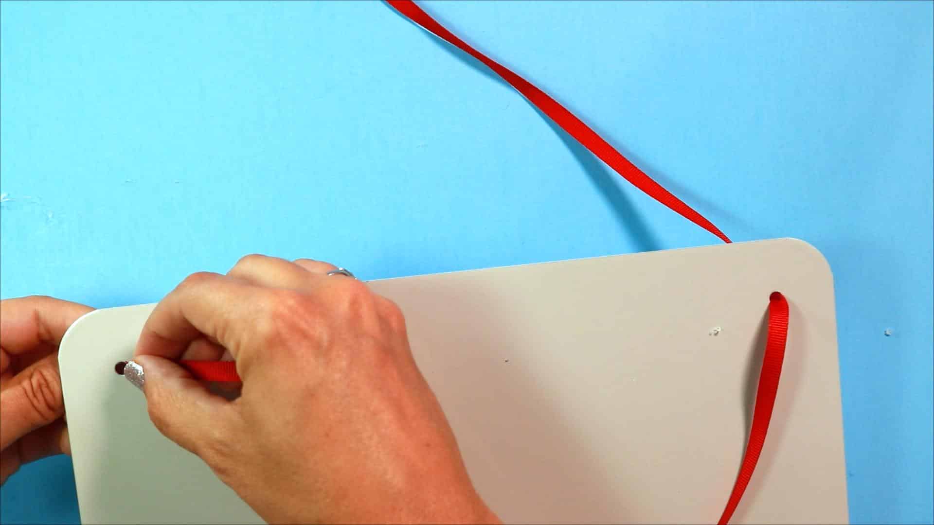 Adding ribbon to magnetic board to hang