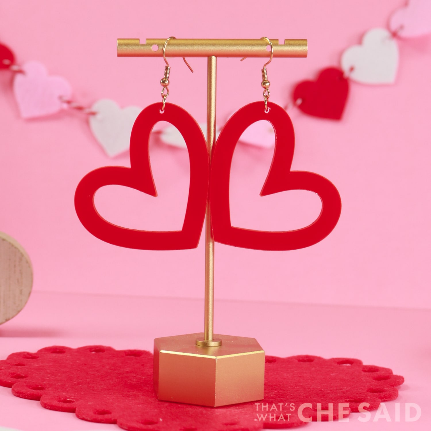 Whimsical Heart earrings cut from acrylic on xtool M1 hanging from earring stand Close up