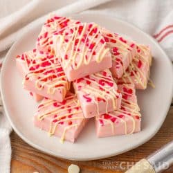Valentine Sugar Cookie Fudge stacked on a white plate with towel - square