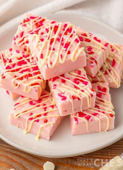 Valentine Sugar Cookie Fudge stacked on a white plate with towel - square