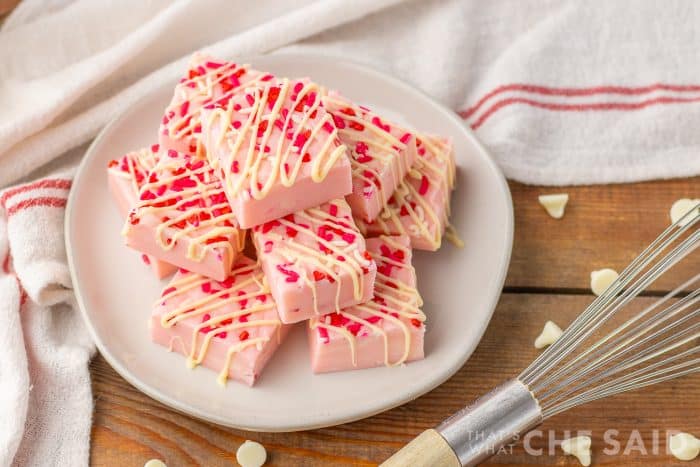Valentine Sugar Cookie Fudge on a white plate with a towel and a horizontal close up