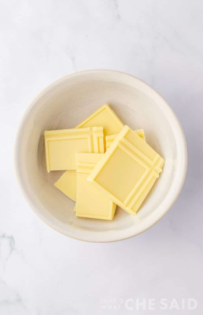 Whtie chocolate bar pieces in a microwave safe bowl - vertica