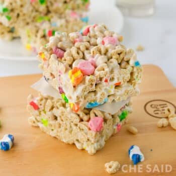 Lucky charms treat bars stacked on a cutting board square orientation