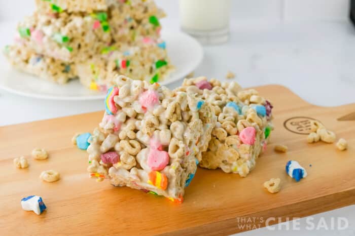 Two cut Lucky Charm Treat bars stacked on a cutting board close up view - horizontal orientation