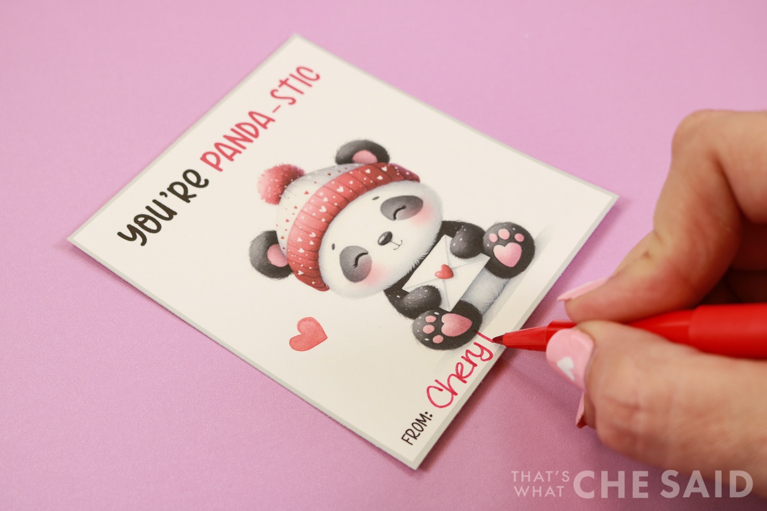 Signing panda valentines with red flair pen