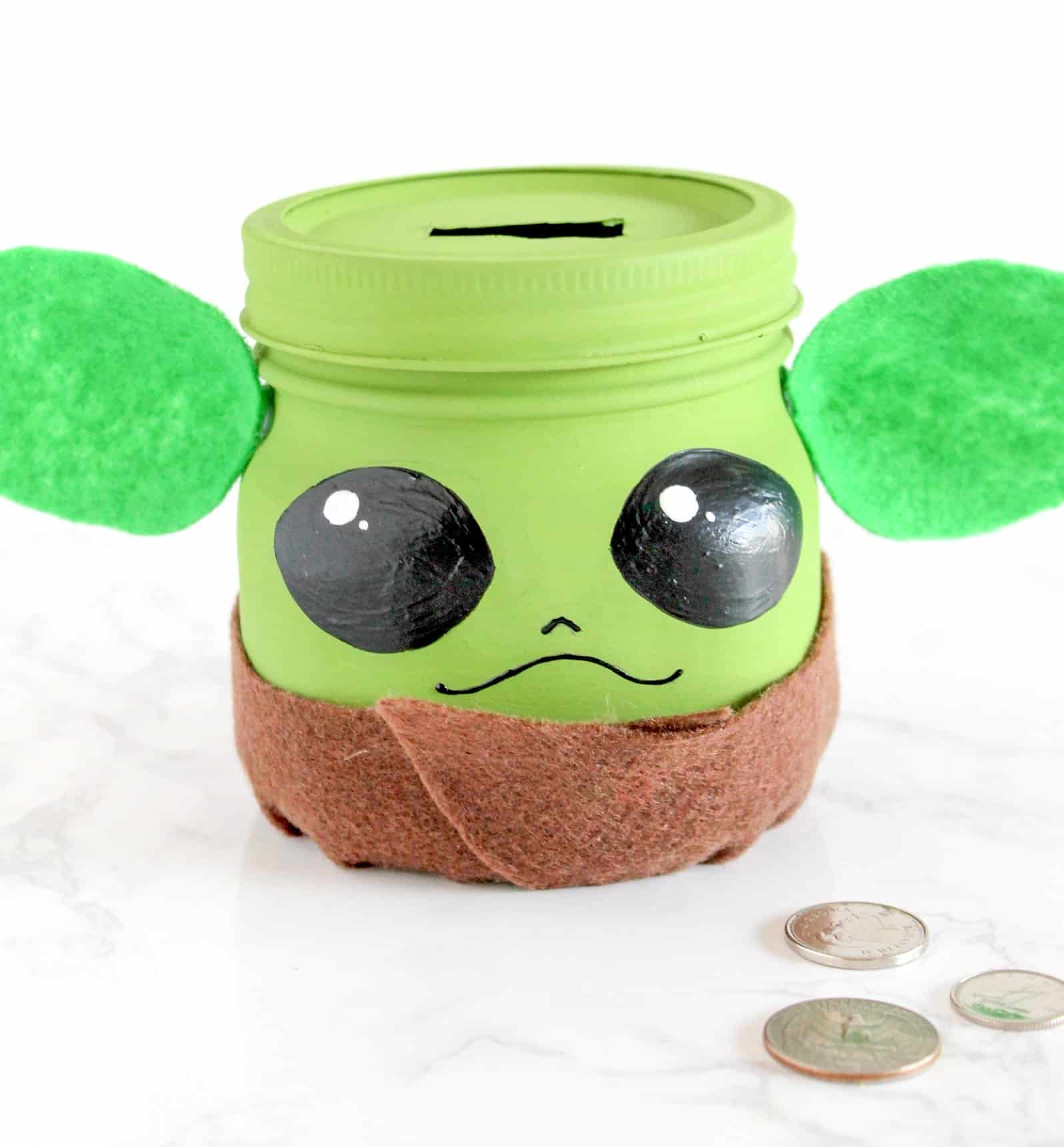 Mason jar painted like yoda and used as a bank