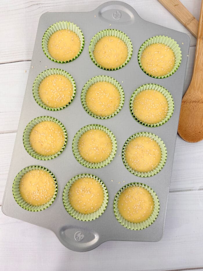 yellow cake mix in cupcake tin with sesame seeds on top for burger buns
