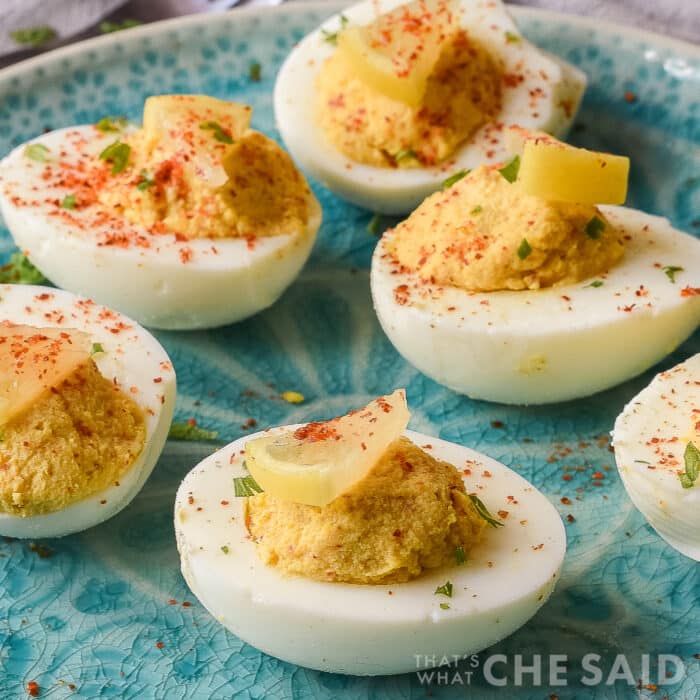 Square image of smoky spicy devilled eggs topped with paprika