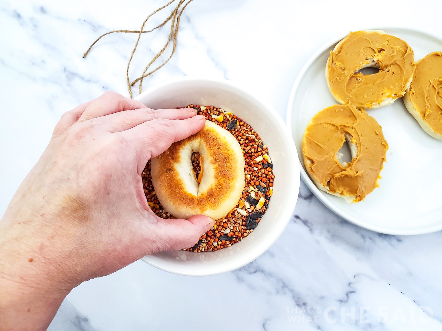 Dipping bagels with peanut butter into bird seed