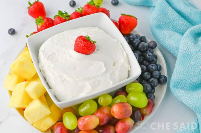 Cool Whip Fruit dip in a square dish with fruit around it, with blue towel Horizontal orientation