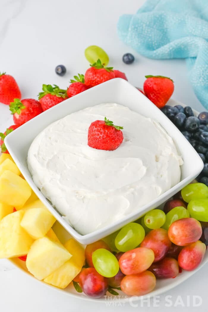 Cool Whip Fruit dip in a square dish with fruit around it, vertical orientation