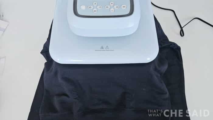 The HTVRont Auto Heat Press 2 pressing a black sweatshirt
