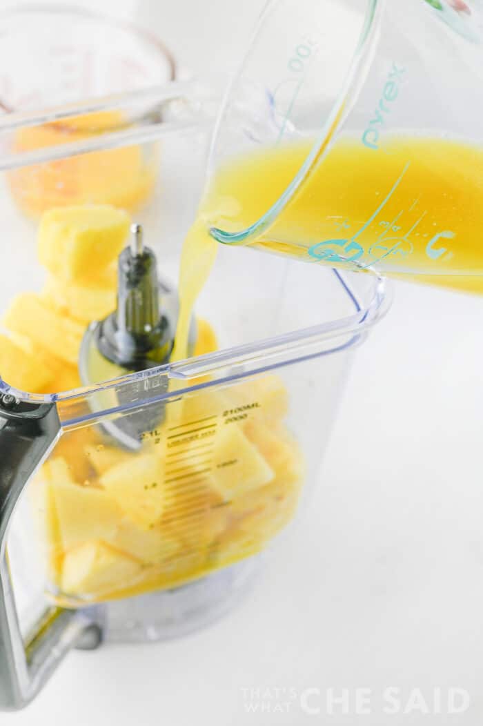 adding juice to frozen pineapple in blender