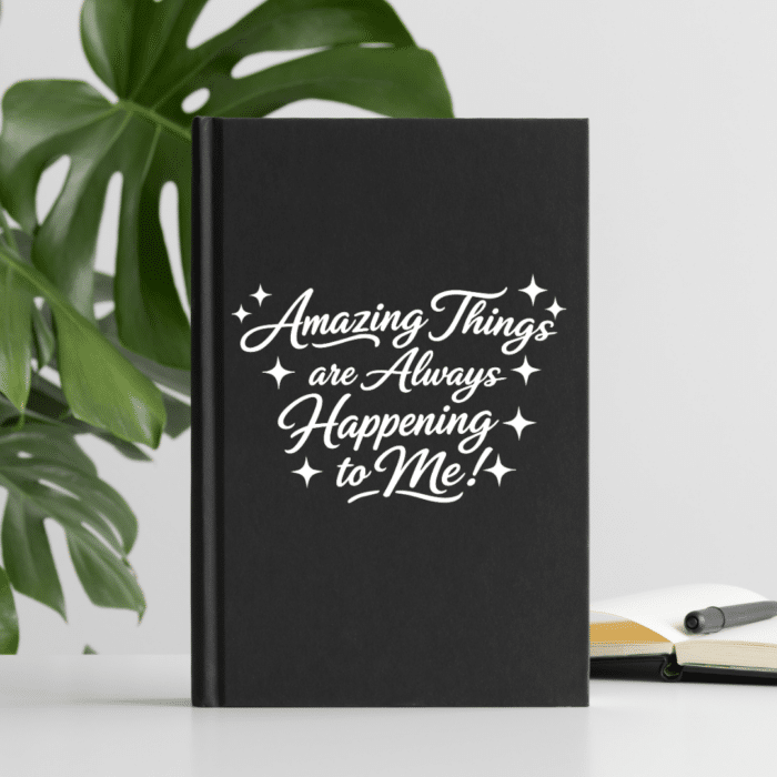 Black journal in front of a monstera plant with amazing things are always happening to me on front